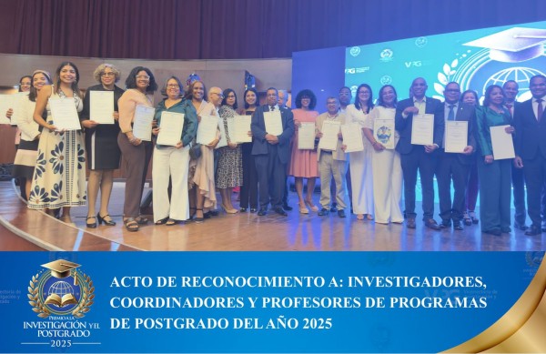 Fotografía de un numeroso grupo de hombres y mujeres, investigadores de la Universidad Autónoma de Santo Domingo (UASD), de pie en el escenario del Aula Magna. Todos sostienen certificados de reconocimiento. El fondo muestra una pantalla gigante con logos de la universidad. En la parte inferior de la imagen, un cintillo azul con letras blancas y un logo dorado dice: 'ACTO DE RECONOCIMIENTO A: INVESTIGADORES, COORDINADORES Y PROFESORES DE PROGRAMAS DE POSTGRADO DEL AÑO 2025'.
